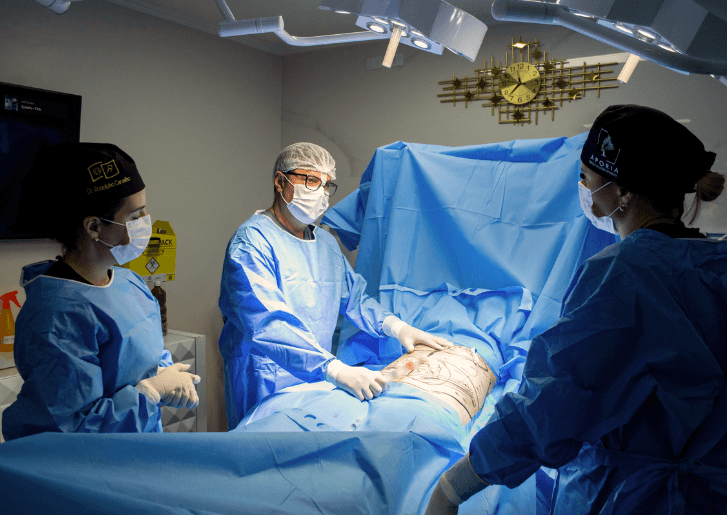 Equipe médica durante cirurgia em ambiente hospitalar com estrutura moderna e protocolos de segurança.